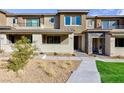 Charming two-story townhouse with neutral exteriors, manicured landscaping and walkway at 11439 Peak Landing Ave, Las Vegas, NV 89138