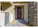 Stylish front entryway with a stone accent wall and dark wooden door at 11439 Peak Landing Ave, Las Vegas, NV 89138
