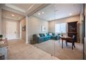 Bright office features glass doors, a comfortable sofa, desk, and access to the home's entry at 11701 Hatchling Ave, Las Vegas, NV 89138