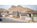 A neighborhood street showcasing modern homes with desert landscaping, complemented by a view of mountains at 11701 Hatchling Ave, Las Vegas, NV 89138