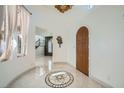 Elegant foyer features a decorative tiled floor, arched doorway, and staircase with stone accent wall at 12254 La Prada Pl, Las Vegas, NV 89138