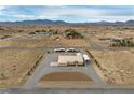 Expansive aerial view of a property with a large lot, desert landscape and mountain backdrop at 1550 Tiptop Trl, Pahrump, NV 89048