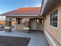 Close-up of welcoming front porch with stone pillars, tiled roof, and ample natural light at 1900 E Highland Ave, Pahrump, NV 89048