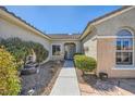 Inviting walkway leading to the front door of this lovely home, framed by lush landscaping and charming details at 2715 Riceville Dr, Henderson, NV 89052