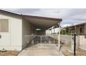 View of gated carport with white metal gate and parking for one car at 3231 Comitan Ln, Las Vegas, NV 89122