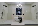 Modern bathroom with a freestanding tub between glass-enclosed double showers and a chandelier at 5573 San Florentine Ave, Las Vegas, NV 89141