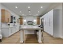 Spacious kitchen with large center island, modern appliances, light countertops, and custom white and wood cabinetry at 5573 San Florentine Ave, Las Vegas, NV 89141