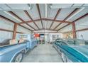 Spacious garage featuring two classic cars, a workbench, and ample storage space at 620 W Leffner Dr, Pahrump, NV 89060