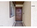 Close-up of the solid wood front door with decorative details and a side window at 6309 Fairbanks Rd, Las Vegas, NV 89103