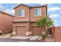 Two-story townhome with two-car garage in desert landscaping at 693 Calamus Palm Pl, Henderson, NV 89011