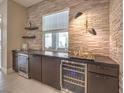Stylish wet bar featuring stacked stone backsplash, floating shelves, and dual wine refrigerators at 72 Reverie Heights Ave, Henderson, NV 89011
