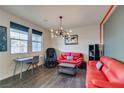 Bright living room featuring a red sofa, modern lighting, and dark wood-look flooring at 748 Fast Green Way, Las Vegas, NV 89148
