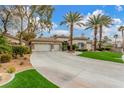 Beautiful single-story home featuring a three car garage, lush landscaping, and large paved driveway at 7816 Sandy Eagle Ct, Las Vegas, NV 89129