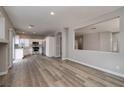 Spacious living area showcasing wood-look floors and an open layout with seamless kitchen access at 7836 Pinnochio Ave, Las Vegas, NV 89131