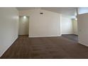 Spacious carpeted living room with neutral paint, a high ceiling, and an open doorway to another room at 8009 Draco Cir # 201, Las Vegas, NV 89128