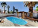 A refreshing pool surrounded by lush palm trees and a cozy wooden pergola at 1004 Country Skies Ave, Las Vegas, NV 89123