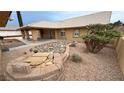 Home's backyard features a rock feature surrounded by well-maintained landscaping at 1211 Bourbon St, Pahrump, NV 89048