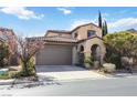 Inviting two-story home with a tile roof, a two car garage and desert landscaping at 12125 Las Hurdes Ave, Las Vegas, NV 89138