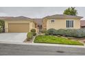 Inviting single-story home featuring manicured landscaping, a two-car garage, and a tile roof at 2385 Orangeburg Pl, Henderson, NV 89044