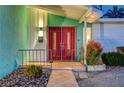 Inviting front entrance featuring a decorative red double door, desert landscaping, and unique exterior lighting at 3220 Pawnee Dr, Las Vegas, NV 89169