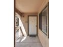 Front door of unit 207 with covered porch, window, and exterior light at 5138 S Jones Blvd # 207, Las Vegas, NV 89118