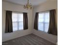 Cozy bedroom with plush carpet, natural light from two windows with curtains, and a decorative light fixture at 520 Arrowhead Trl # 1411, Henderson, NV 89015