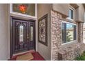 Close-up of an elegant stained wood front door, with decorative glass and wrought iron security gate at 8953 Belconte Ln, Henderson, NV 89074