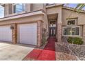 Elegant front entrance with stone accents, a red walkway, and a charming hanging light fixture at 8953 Belconte Ln, Henderson, NV 89074