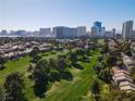 Scenic aerial view of the community with lush green golf course and city buildings on the horizon at 914 Tam O Shanter, Las Vegas, NV 89109