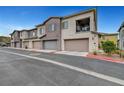 View of townhome exteriors with attached garages, displaying modern architecture and individual unit entrances at 965 Nevada State Dr # 38202, Henderson, NV 89002