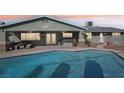 Inviting backyard with a refreshing pool, covered patio, and outdoor seating, perfect for relaxation and entertainment at 1912 Parkchester Dr, Las Vegas, NV 89108