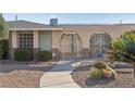 Unique desert home with arched front gate, low maintenance landscaping, and solar panels on the roof at 1912 Parkchester Dr, Las Vegas, NV 89108