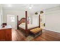 Comfortable bedroom featuring a four-poster bed, hardwood floors, and a ceiling fan at 274 Aztec Ln, Henderson, NV 89015