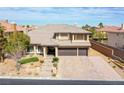 Elegant two-story home featuring a three-car garage, stone accents, and meticulously landscaped front yard at 4372 Melrose Abbey Pl, Las Vegas, NV 89141