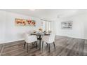 Dining room features wood flooring, light neutral paint, modern light fixture and views to backyard at 5272 Blanton Dr, Las Vegas, NV 89122