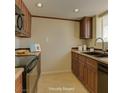 Traditional kitchen with dark wood cabinets, tile flooring, and neutral countertops at 5345 Silvermist Ct # 203, Las Vegas, NV 89122