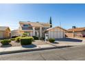 Inviting two-story home boasts a manicured lawn and a two-car garage at 637 Otono Dr, Boulder City, NV 89005