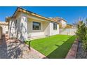 A manicured backyard featuring artificial turf and a brick border for easy maintenance at 669 Elliot Peak Ave, Las Vegas, NV 89183