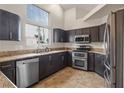 Modern kitchen with stainless steel appliances, granite countertops, and dark wood cabinets at 845 Holly Lake Way, Henderson, NV 89002