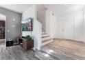 Bright living area with wood flooring, staircase, and a stylish television on the wall at 1030 Wild Fern Ct, Las Vegas, NV 89183