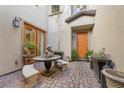Inviting courtyard with stone benches, dining table, and vibrant potted plants at 12125 Edgehurst Ct, Las Vegas, NV 89138