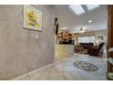 Open-concept foyer with a view into the living room, featuring tile floors and decorative wall finishes at 1700 Wellington Springs Ave, Henderson, NV 89052