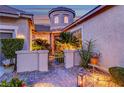 Stone accents highlight the entryway, framed by mature palms, shrubbery, and an iron gate at 2264 Pacini Ct, Henderson, NV 89052