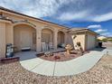 Exterior view of home with covered porch, two rocking chairs, desert landscaping at 2300 S Washoe Ave, Pahrump, NV 89048