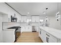 Bright kitchen featuring white cabinets, stainless steel appliances, and a backsplash with black hardware at 2521 Richfield Blvd, Las Vegas, NV 89102