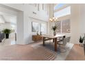 Elegant dining room with modern chandelier, large windows, and stylish furnishings perfect for entertaining guests at 2743 Carolina Blue Ave, Henderson, NV 89052