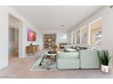 Cozy living room with large windows, featuring a comfortable sectional sofa, fireplace, and built-in shelving at 2743 Carolina Blue Ave, Henderson, NV 89052