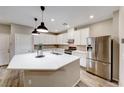 Bright kitchen features a large island, stainless steel appliances, modern pendant lighting, and ample counter space at 2844 Alenga St, Henderson, NV 89044