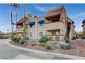 Condo building featuring desert landscaping, blue awnings, and an exterior staircase at 4140 Gannet Cir # 255, Las Vegas, NV 89103
