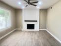 Bright living room featuring a brick fireplace and wood-look flooring at 4194 Greenpoint St, Las Vegas, NV 89147
